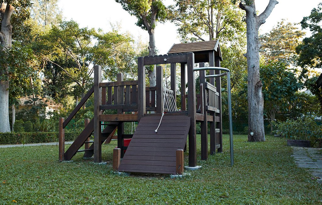 Spielplatz aus dunklem Holz im Garten