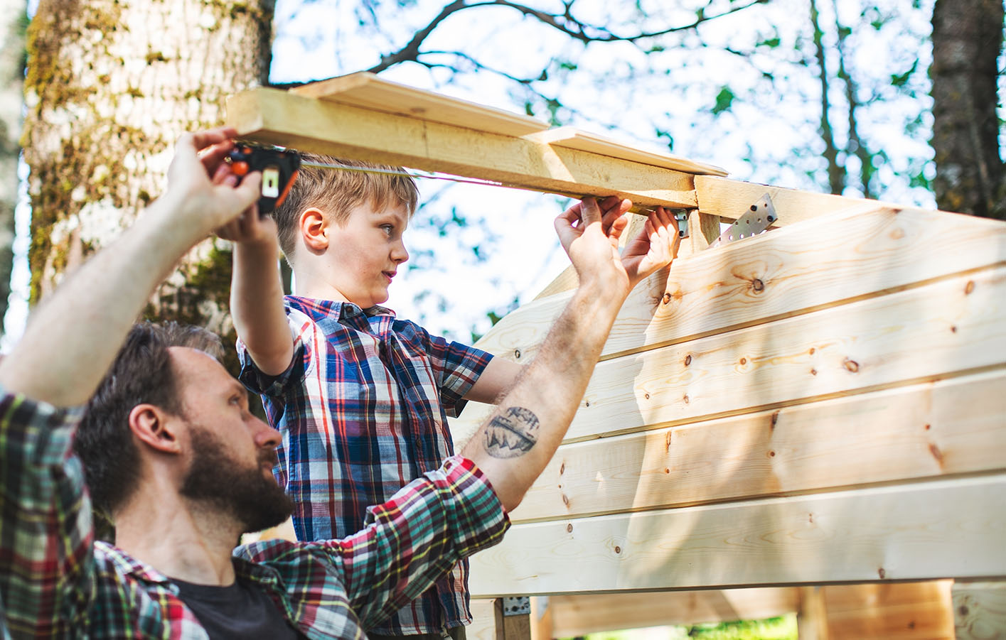 Vater und Sohn bauen ein Gartenhaus mit Konstruktionsholz