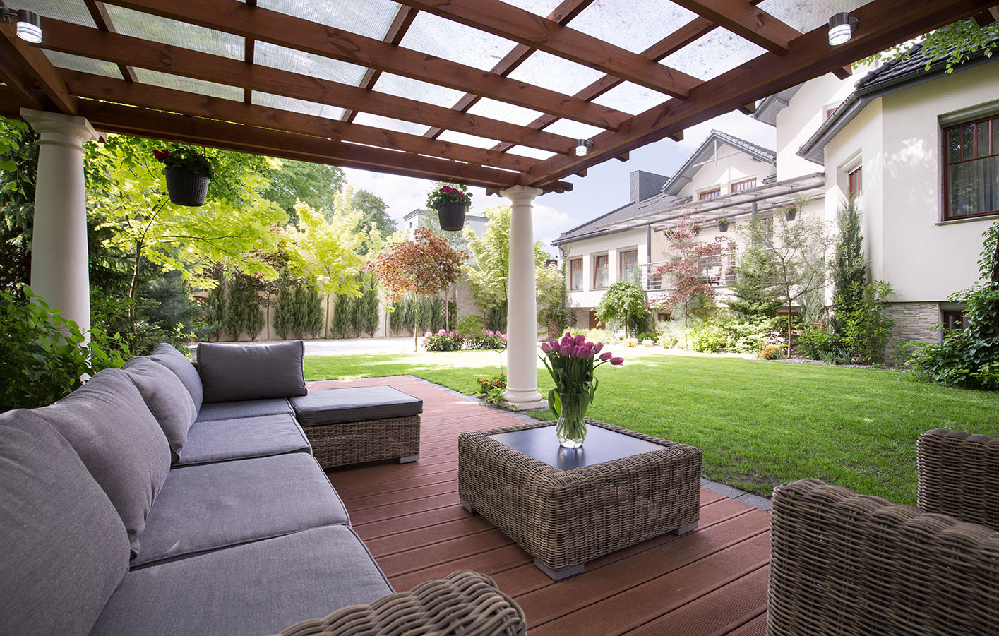 Eine mit Holzbalken und PVC überdachte Sitzecke in einem Garten