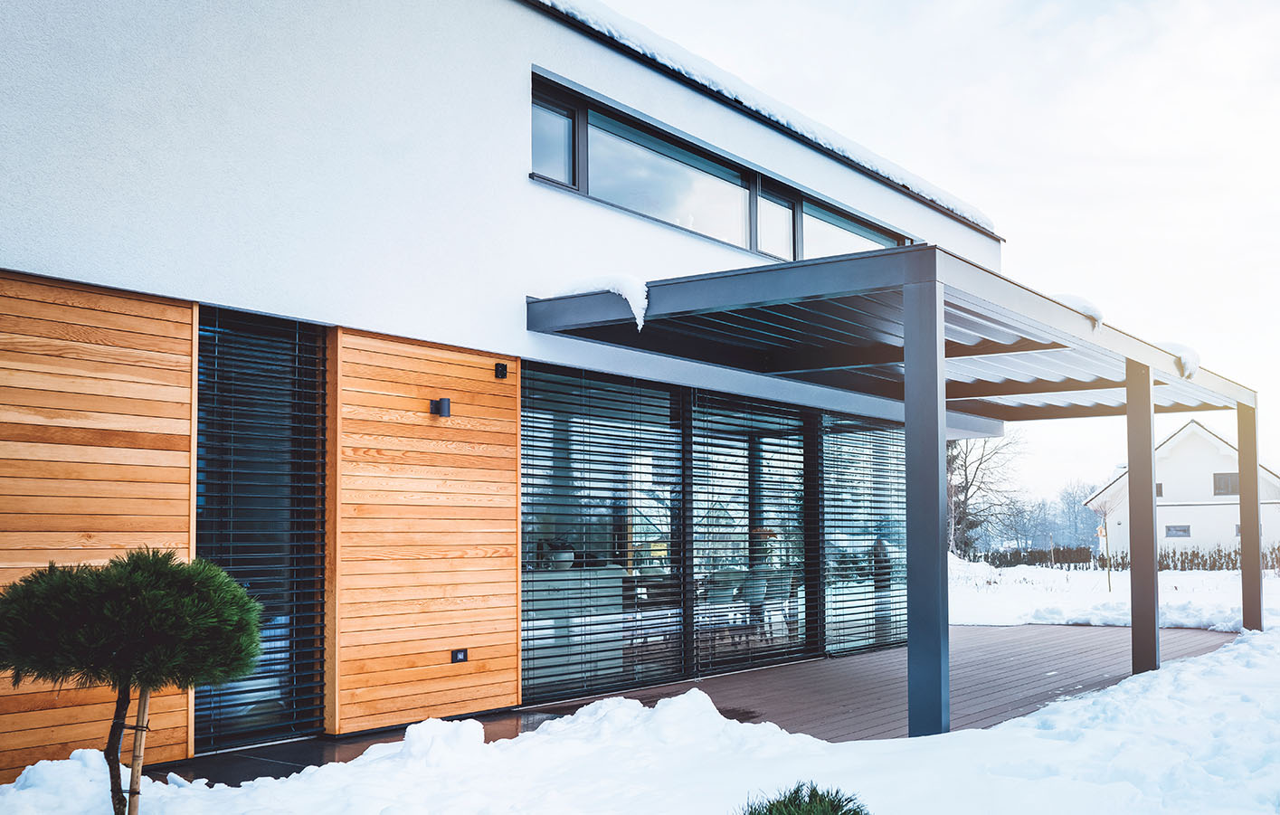Haus mit Flachdach mit einem Mix aus Holzfassade, Rauputz und Glasfront